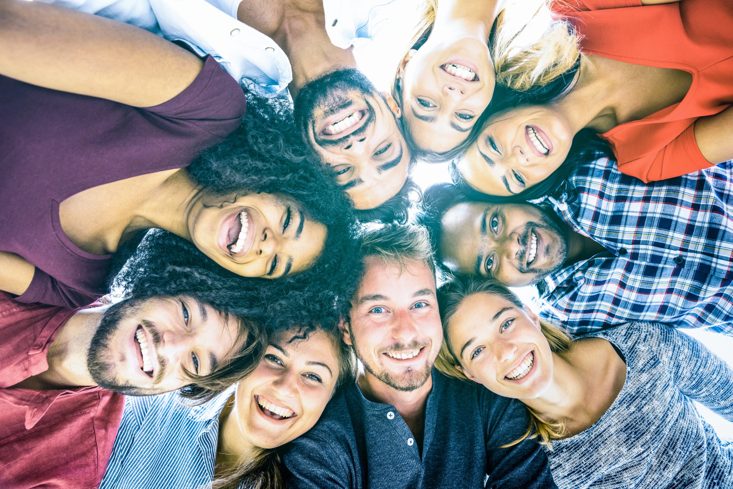 Multiracial best friends millennials taking selfie outdoors with back lighting - Happy youth friendship concept against racism with international young people having fun together - Azure filter tone